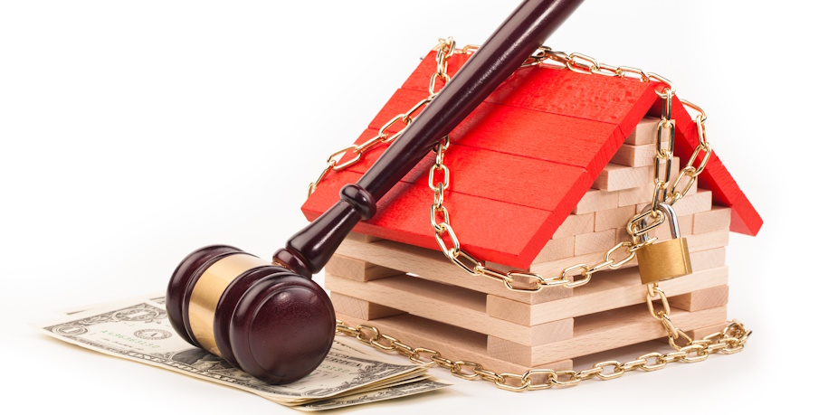 gavel leaning on wooden house