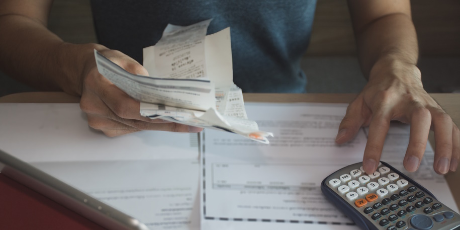 man using calculator for calculate expenses accounts