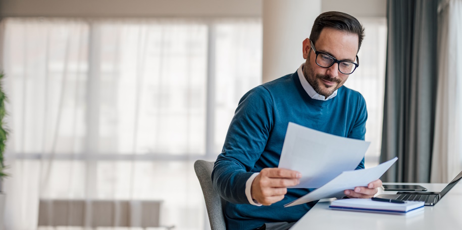 man looking at papers at a desk