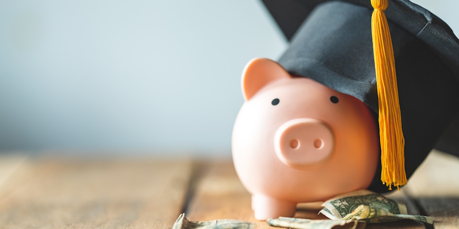piggy bank with money and graduation cap