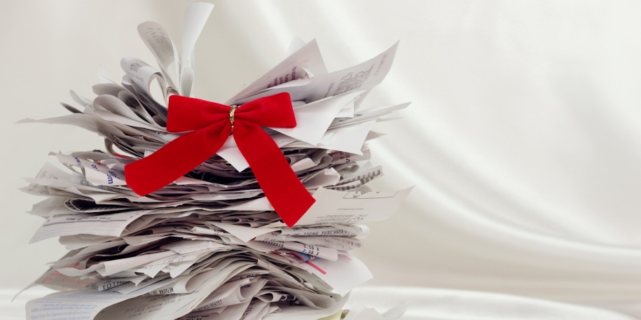 stack of holiday shopping receipts with red bow on top